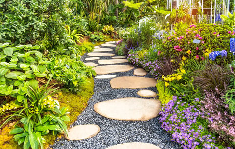 Beautiful garden path leading through lush garden with flower beds